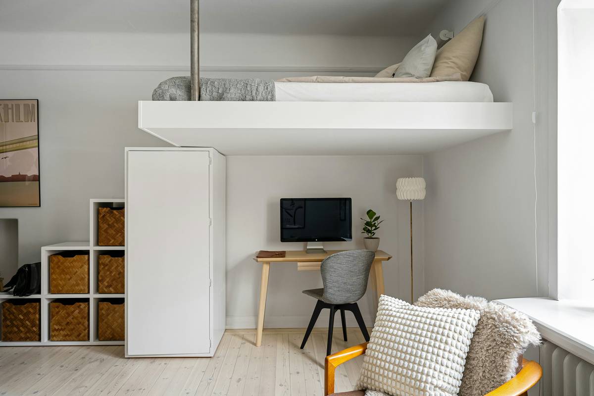 loft bed with built in desk showing a twin mattress elevated above a pull-out writing surface, metal frame, under-bed clearance of 42 inches